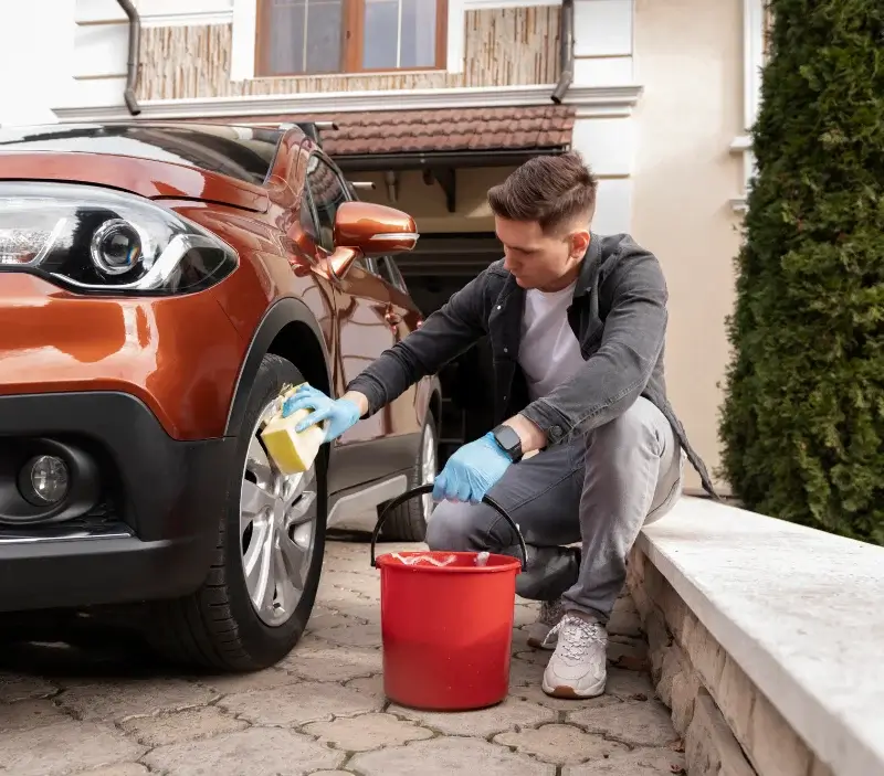 Lavage auto à domicile Cour-l'Évêque : professionnel intervenant sur un véhicule